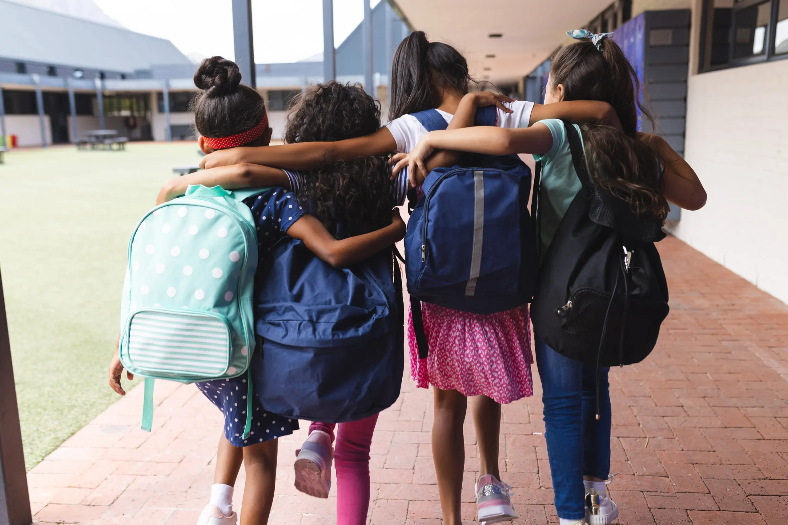 Young girls walking together down a hallway at school